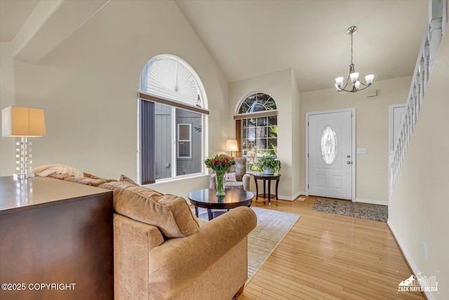 10201 Sextant Cir, Anchorage, AK 99515 - entryway featuring a chandelier, light wood-type flooring, high vaulted ceiling, baseboards, and stairs