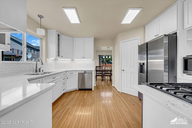 10201 Sextant Cir, Anchorage, AK 99515 - kitchen with appliances with stainless steel finishes, a sink, white cabinetry, and backsplash