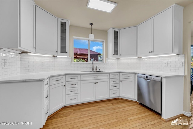 10201 Sextant Cir, Anchorage, AK 99515 - kitchen with stainless steel dishwasher, a sink, light wood-style flooring, white cabinets, and decorative light fixtures