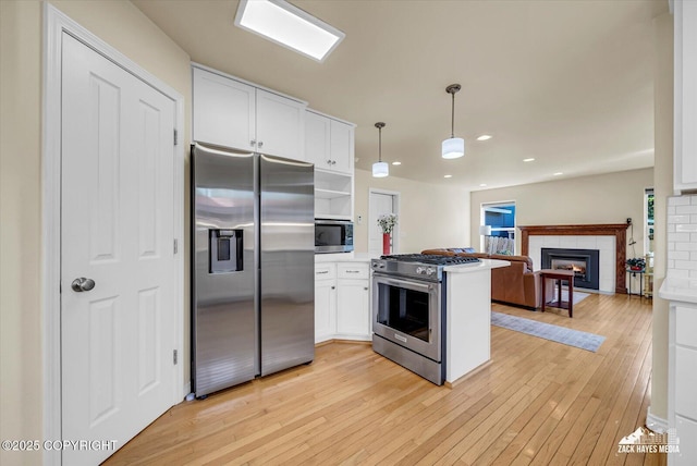 10201 Sextant Cir, Anchorage, AK 99515 - kitchen featuring stainless steel appliances, a peninsula, light wood-style flooring, white cabinets, and open floor plan