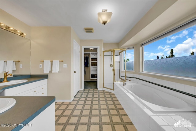 10201 Sextant Cir, Anchorage, AK 99515 - bathroom featuring vanity, a stall shower, a garden tub, a walk in closet, and tile patterned floors