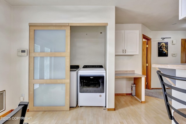 4160 Crannog St, Anchorage, AK 99502 - laundry area with light wood-type flooring, baseboards, and washer and clothes dryer