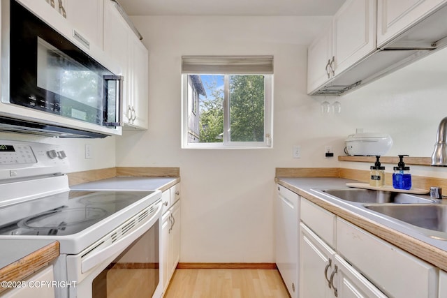 4160 Crannog St, Anchorage, AK 99502 - kitchen featuring white appliances, white cabinets, light wood-style floors, a sink, and light countertops