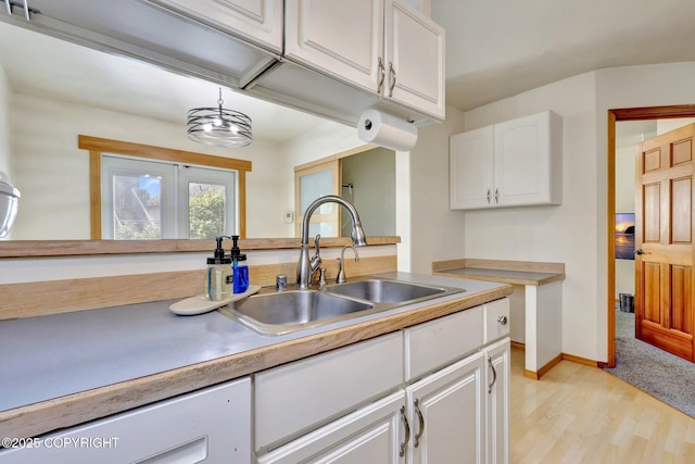 4160 Crannog St, Anchorage, AK 99502 - kitchen featuring a sink, white cabinetry, light wood-style floors, baseboards, and pendant lighting