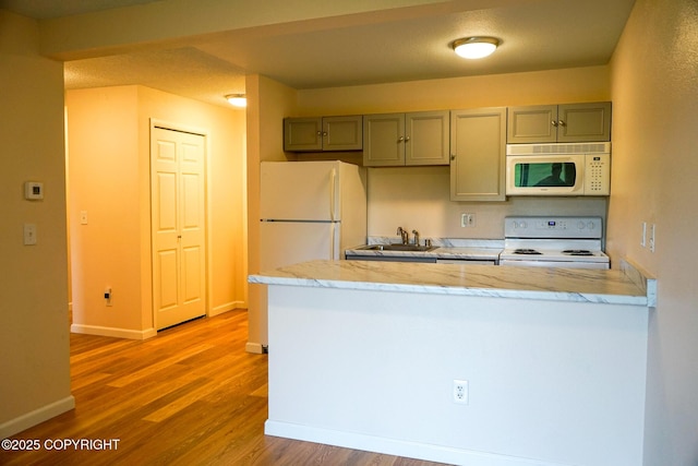 2100 Minerva Way # A6, Anchorage, AK 99515 - kitchen featuring white appliances, a sink, wood finished floors, a peninsula, and gray cabinets