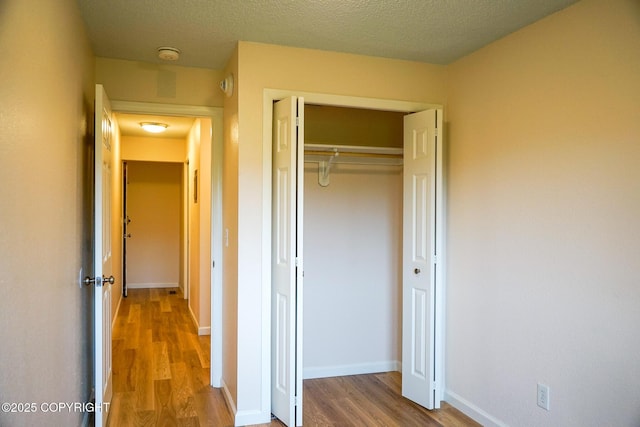 2100 Minerva Way # A6, Anchorage, AK 99515 - unfurnished bedroom with wood finished floors, a closet, baseboards, and a textured ceiling