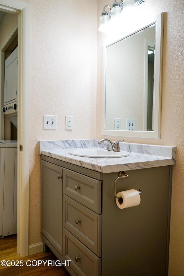 2100 Minerva Way # A6, Anchorage, AK 99515 - bathroom with vanity, wood finished floors, and stacked washer / dryer