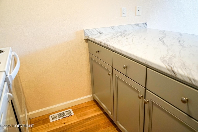 2100 Minerva Way # A6, Anchorage, AK 99515 - detailed view of white range, wood finished floors, and baseboards