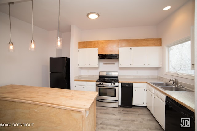 3139 Rosella St # G, Anchorage, AK 99504 - kitchen featuring black appliances, under cabinet range hood, light wood finished floors, white cabinets, and hanging light fixtures