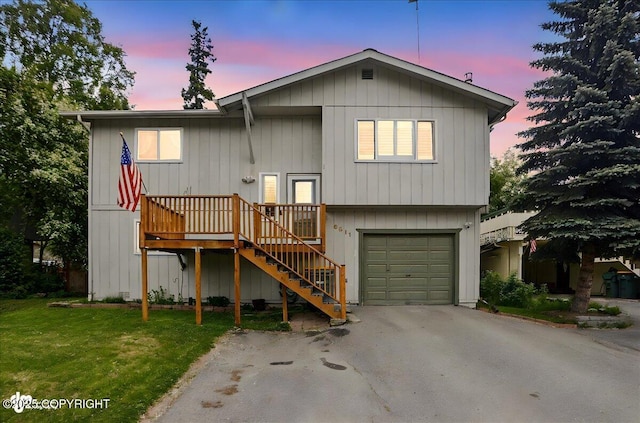 6911 Cheryl St, Anchorage, AK 99518 - view of front of property with driveway, an attached garage, stairway, a lawn, and a wooden deck