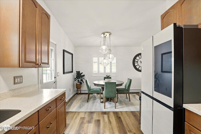 6911 Cheryl St, Anchorage, AK 99518 - dining room featuring light wood-type flooring, a chandelier, baseboard heating, and baseboards