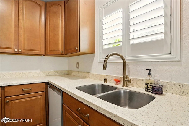 6911 Cheryl St, Anchorage, AK 99518 - kitchen featuring a sink, dishwasher, brown cabinetry, and light stone countertops