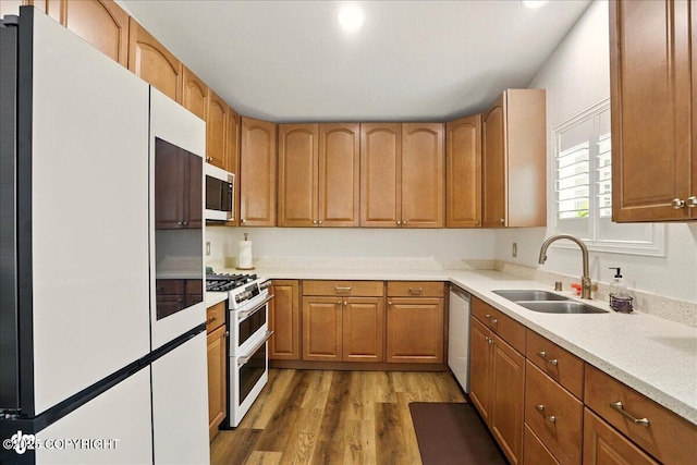 6911 Cheryl St, Anchorage, AK 99518 - kitchen with freestanding refrigerator, double oven range, a sink, stainless steel microwave, and wood finished floors