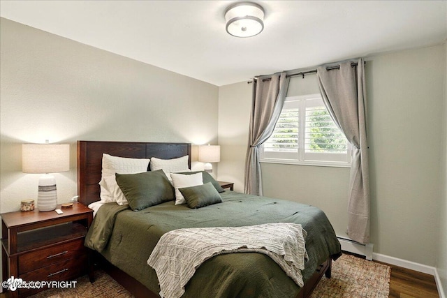 6911 Cheryl St, Anchorage, AK 99518 - bedroom featuring baseboard heating, wood finished floors, and baseboards