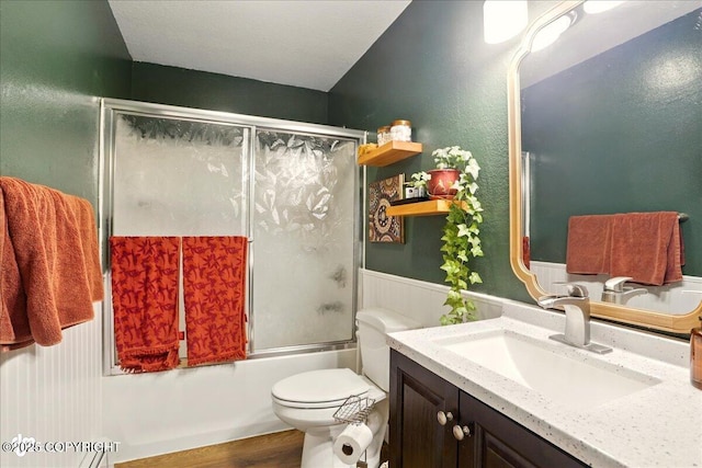6911 Cheryl St, Anchorage, AK 99518 - bathroom featuring vanity, combined bath / shower with glass door, toilet, and wood finished floors