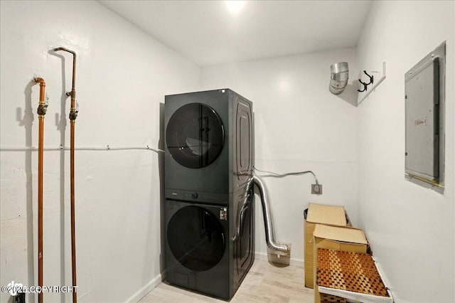 6911 Cheryl St, Anchorage, AK 99518 - laundry area featuring stacked washer / drying machine, electric panel, baseboards, and light wood-type flooring