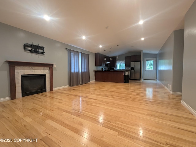 7324 Zurich St, Anchorage, AK 99507 - unfurnished living room featuring light wood-style flooring, lofted ceiling, a fireplace, baseboards, and recessed lighting
