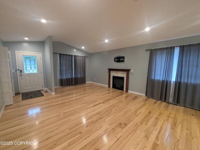 7324 Zurich St, Anchorage, AK 99507 - unfurnished living room featuring light wood-style flooring, lofted ceiling, a fireplace, recessed lighting, and baseboards