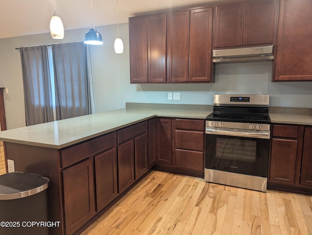 7324 Zurich St, Anchorage, AK 99507 - kitchen featuring electric stove, under cabinet range hood, light wood-style floors, a peninsula, and light countertops