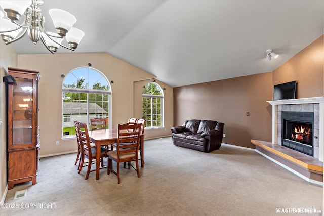 2353 Maritime Loop, Anchorage, AK 99515 - carpeted dining room featuring vaulted ceiling, a chandelier, baseboards, and a tile fireplace