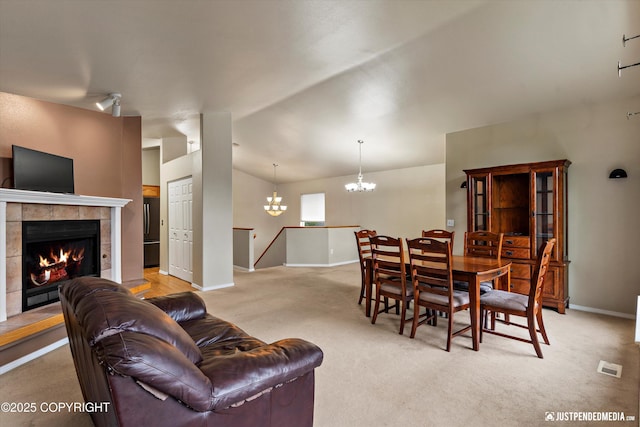 2353 Maritime Loop, Anchorage, AK 99515 - living area with a chandelier, light carpet, baseboards, vaulted ceiling, and a tiled fireplace