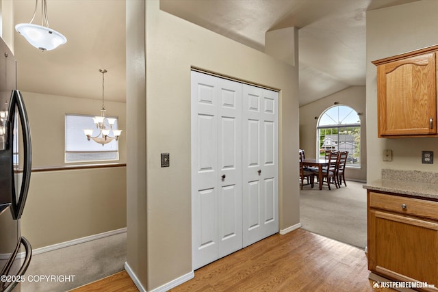 2353 Maritime Loop, Anchorage, AK 99515 - kitchen featuring freestanding refrigerator, light wood-style flooring, a chandelier, vaulted ceiling, and pendant lighting