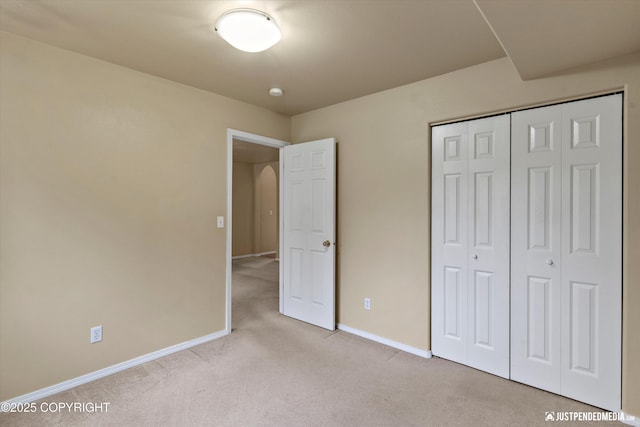 2353 Maritime Loop, Anchorage, AK 99515 - unfurnished bedroom with light colored carpet, baseboards, a closet, and arched walkways