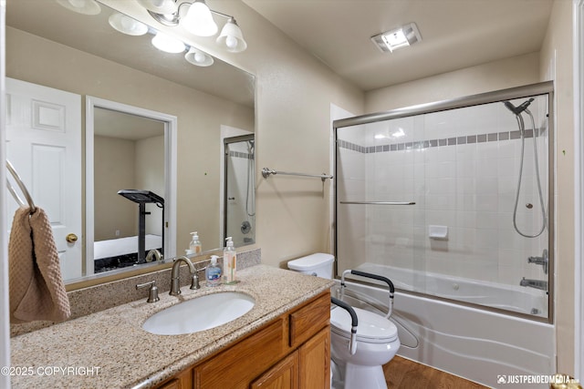 2353 Maritime Loop, Anchorage, AK 99515 - ensuite bathroom featuring toilet, vanity, shower / bath combination with glass door, and wood finished floors