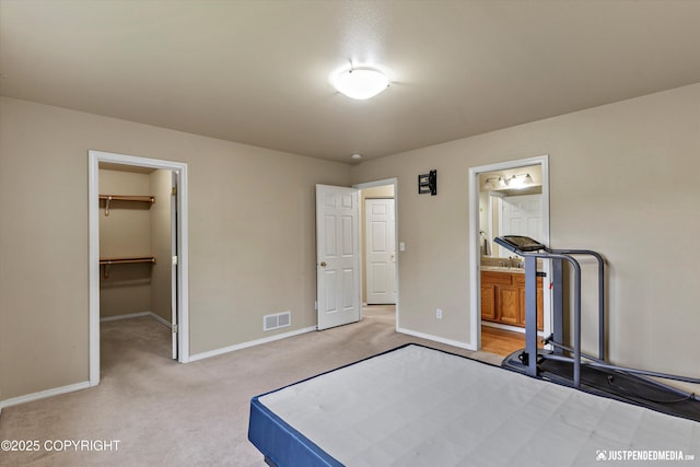 2353 Maritime Loop, Anchorage, AK 99515 - unfurnished bedroom featuring light colored carpet, a spacious closet, baseboards, ensuite bathroom, and a closet