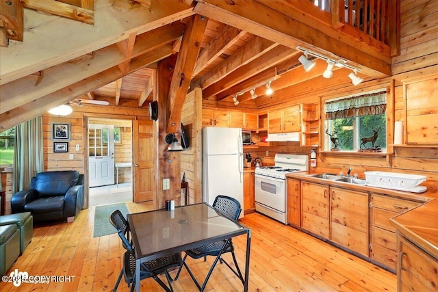 13364 Sterling Hwy, Ninilchik, AK 99639 - kitchen with white appliances, rail lighting, wood walls, under cabinet range hood, and healthy amount of natural light
