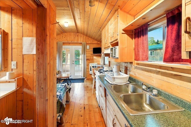 13364 Sterling Hwy, Ninilchik, AK 99639 - kitchen with vaulted ceiling, wooden walls, a sink, plenty of natural light, and light wood-style flooring