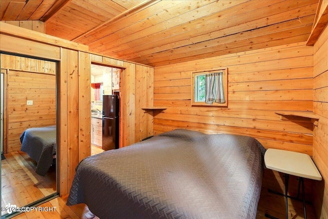 13364 Sterling Hwy, Ninilchik, AK 99639 - bedroom featuring wooden walls, freestanding refrigerator, wood ceiling, and wood-type flooring