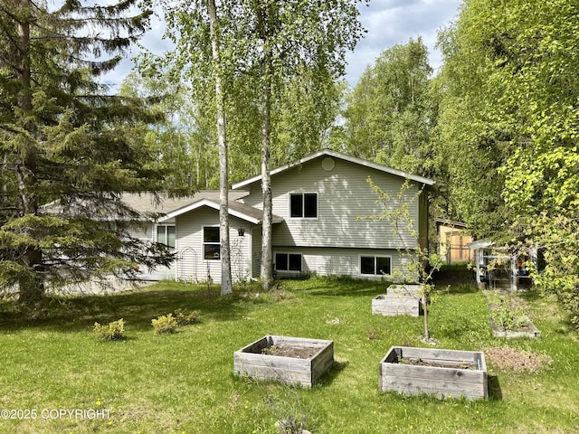 22909 Green Garden Dr, Chugiak, AK 99567 - rear view of property with a garden and a yard