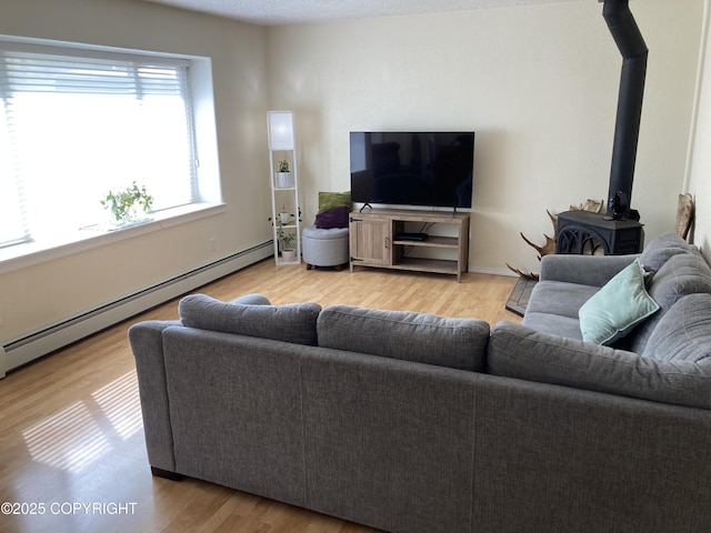 22909 Green Garden Dr, Chugiak, AK 99567 - living room with a baseboard radiator, a wood stove, and light wood finished floors