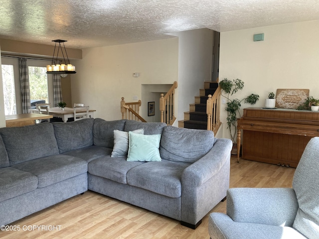22909 Green Garden Dr, Chugiak, AK 99567 - living room featuring a textured ceiling, light wood-type flooring, and stairs