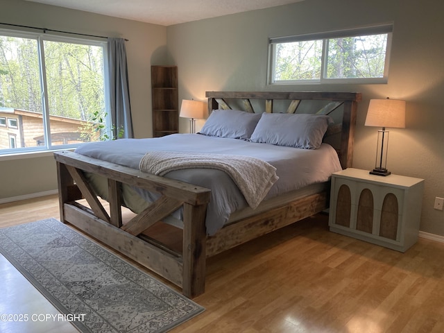 22909 Green Garden Dr, Chugiak, AK 99567 - bedroom with baseboards, multiple windows, and light wood finished floors