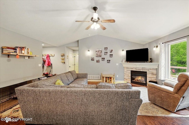 2700 S Hatcher Pass St, Wasilla, AK 99623 - living area featuring vaulted ceiling, wood finished floors, ceiling fan, and a stone fireplace