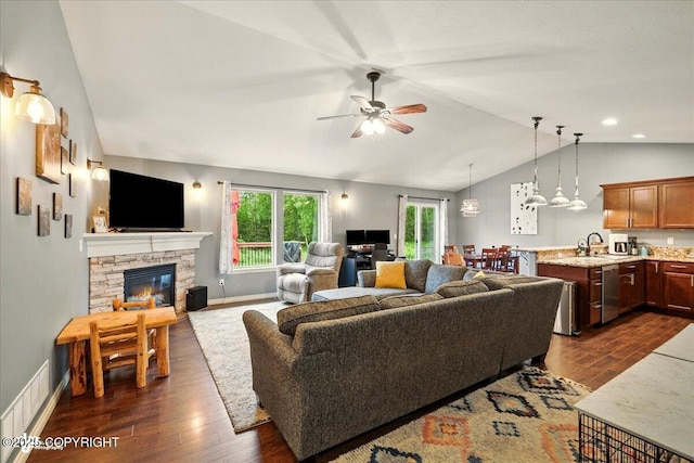 2700 S Hatcher Pass St, Wasilla, AK 99623 - living room with lofted ceiling, dark wood-style floors, ceiling fan, a stone fireplace, and baseboards