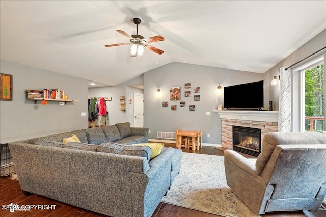 2700 S Hatcher Pass St, Wasilla, AK 99623 - living area featuring dark wood-style flooring, vaulted ceiling, a stone fireplace, and a ceiling fan