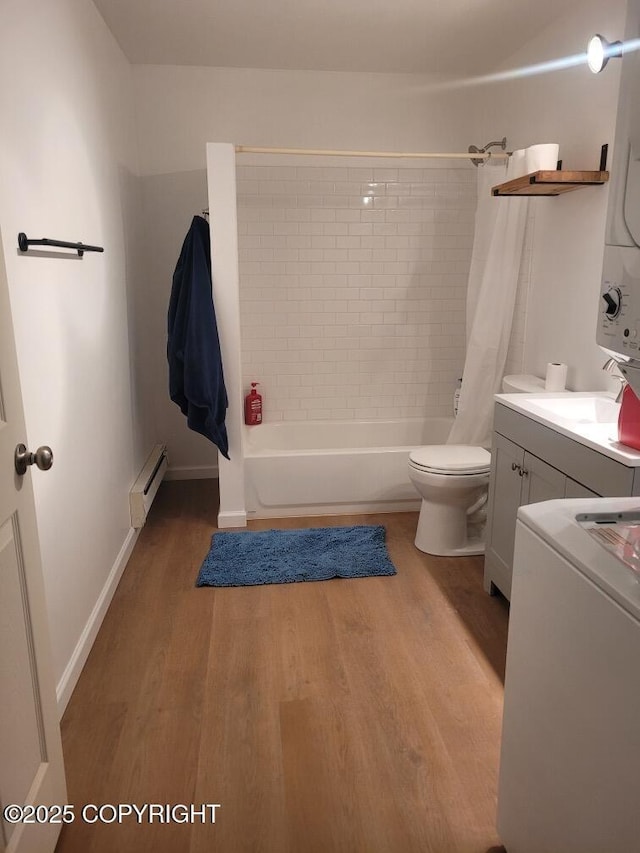 7700 E 32nd Ave, Anchorage, AK 99504 - full bathroom featuring baseboard heating, stacked washing machine and dryer, wood finished floors, toilet, and shower / tub combo with curtain