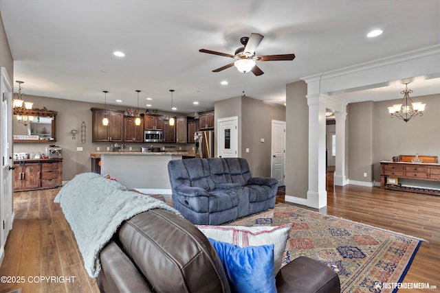 542 S Tender Arctic Dr, Palmer, AK 99645 - living area featuring a ceiling fan, a chandelier, wood finished floors, ornate columns, and recessed lighting
