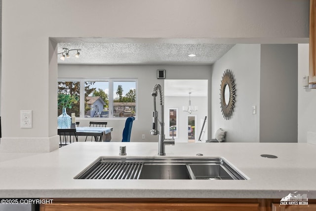 2105 W 47th Ave, Anchorage, AK 99517 - kitchen view of a textured ceiling, a chandelier, and light countertops