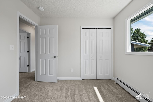 2105 W 47th Ave, Anchorage, AK 99517 - unfurnished bedroom with a baseboard radiator, carpet flooring, a closet, and a textured ceiling