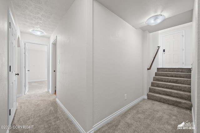 2105 W 47th Ave, Anchorage, AK 99517 - hall featuring a textured ceiling, carpet floors, stairs, and a textured wall