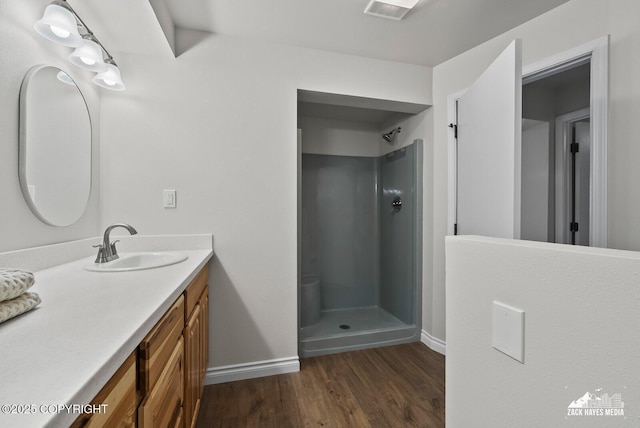 2105 W 47th Ave, Anchorage, AK 99517 - bathroom featuring a stall shower, vanity, and wood finished floors