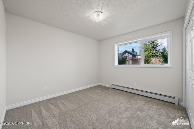 2105 W 47th Ave, Anchorage, AK 99517 - spare room featuring a baseboard heating unit, carpet flooring, and a textured ceiling