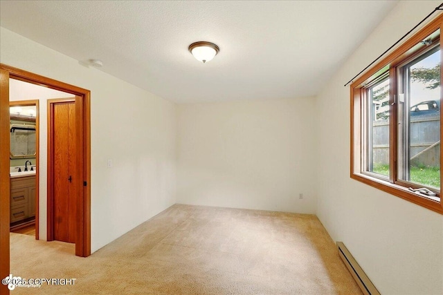 4085 Calhoun St, Homer, AK 99603 - empty room featuring carpet floors, a sink, and a baseboard heating unit
