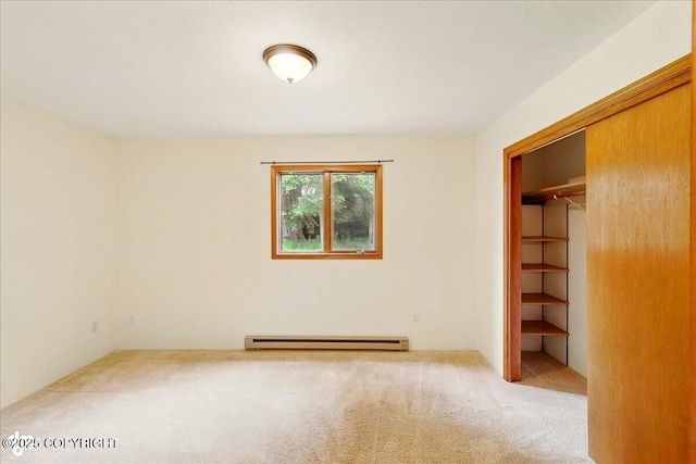 4085 Calhoun St, Homer, AK 99603 - unfurnished bedroom featuring carpet, a baseboard radiator, a closet, and a walk in closet
