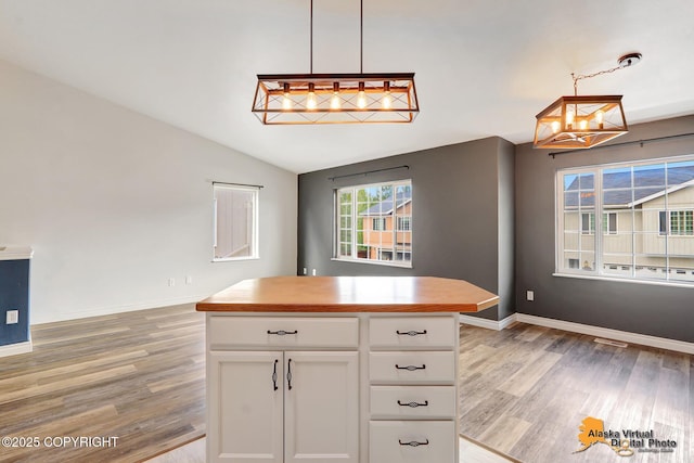 2922 Summer Sun Ct # 154, Anchorage, AK 99507 - kitchen with light wood finished floors, a chandelier, white cabinets, pendant lighting, and lofted ceiling
