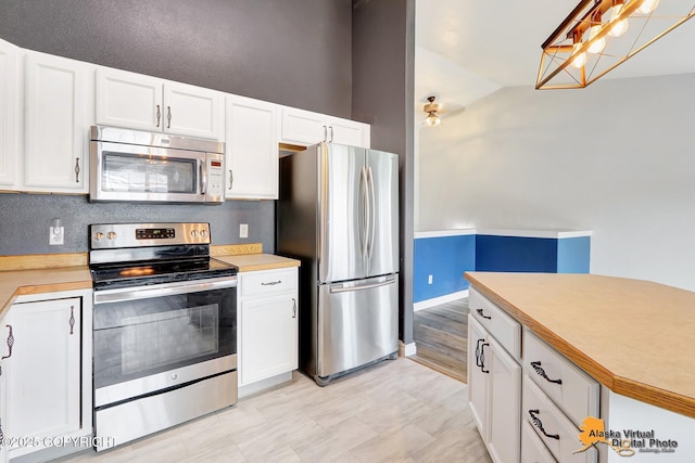 2922 Summer Sun Ct # 154, Anchorage, AK 99507 - kitchen with appliances with stainless steel finishes, light countertops, white cabinets, and vaulted ceiling